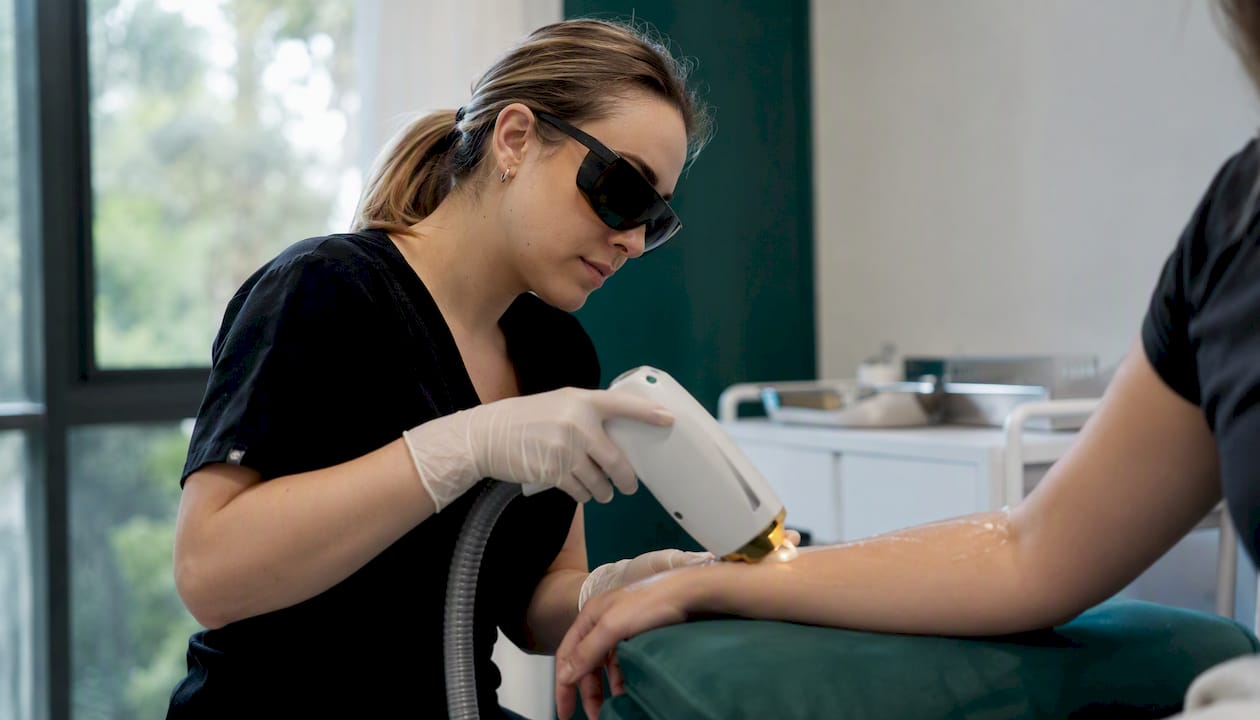 Clinician applying laser hair removal treatment on skin
