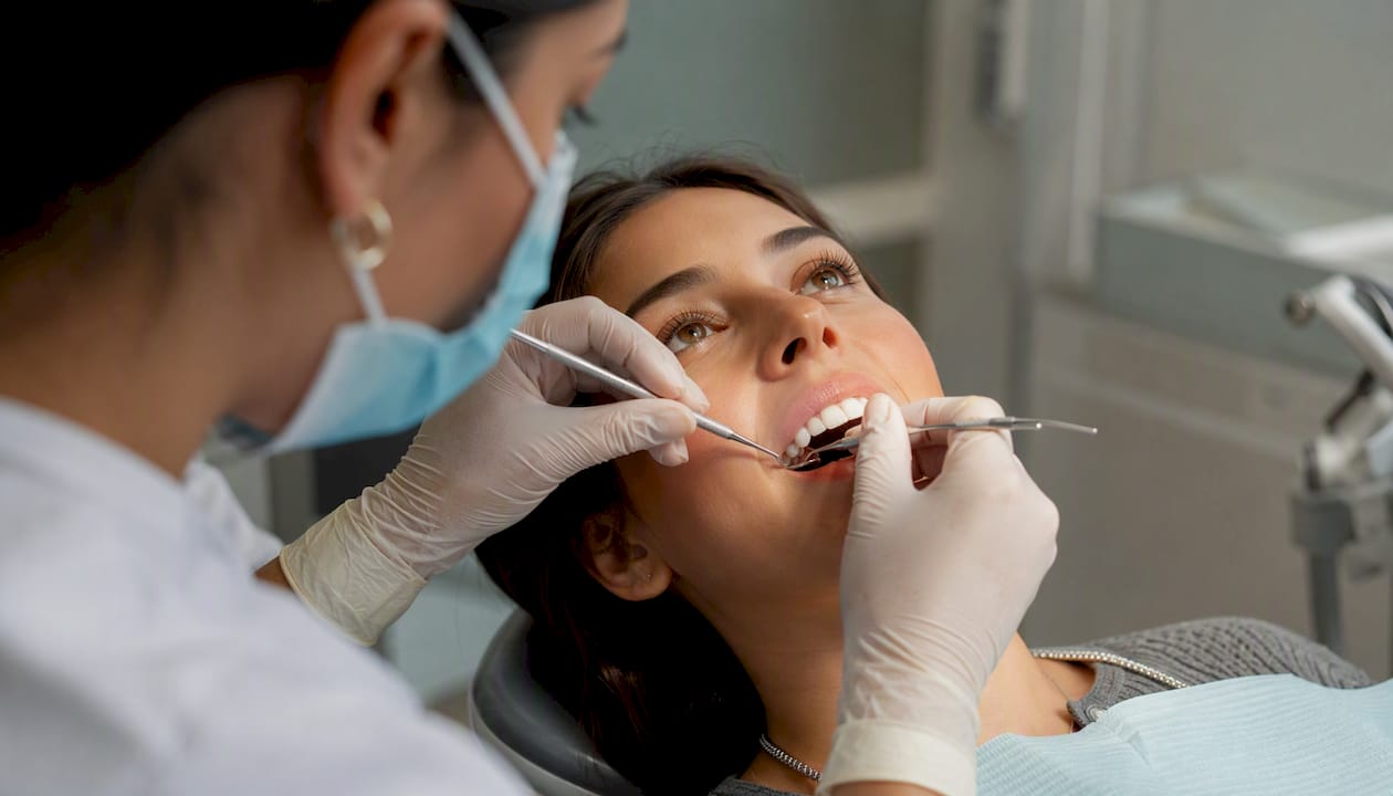 Dentist sculpting composite resin veneer in clinic