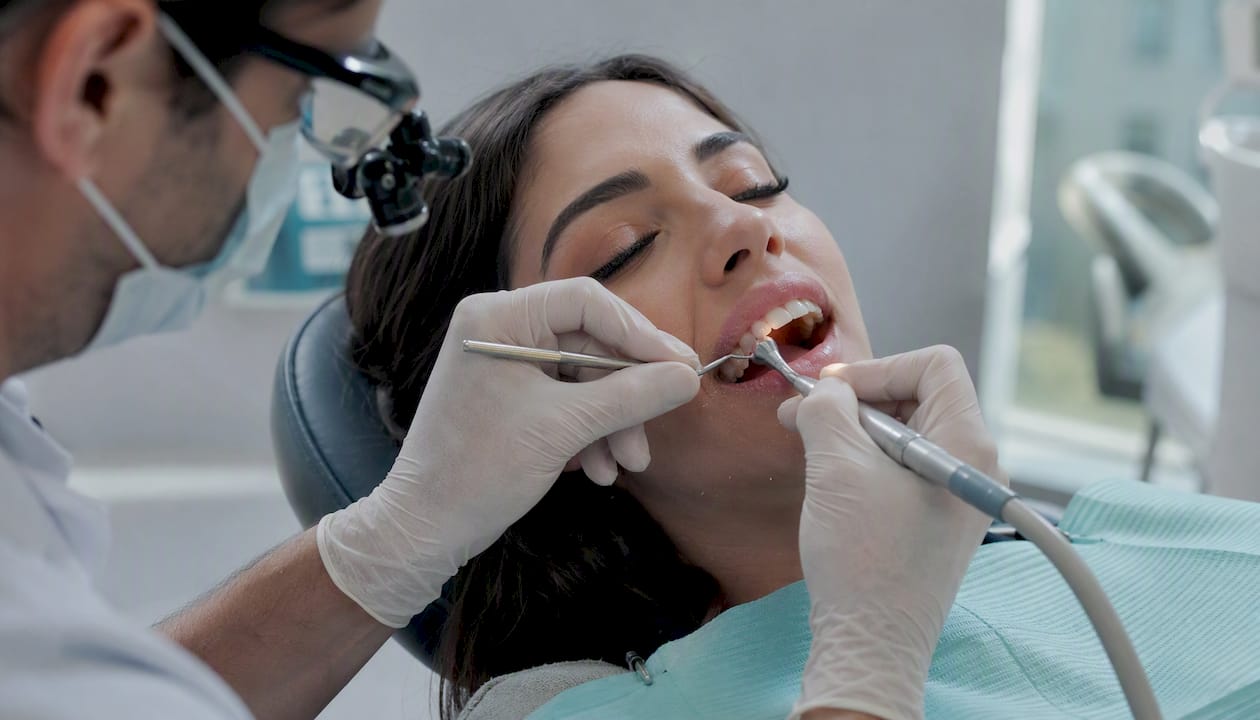Dentist preparing tooth enamel for veneer bonding