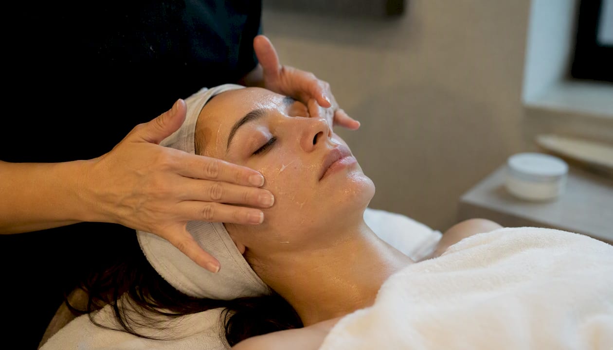 Hand gently cleansing face after chemical peel